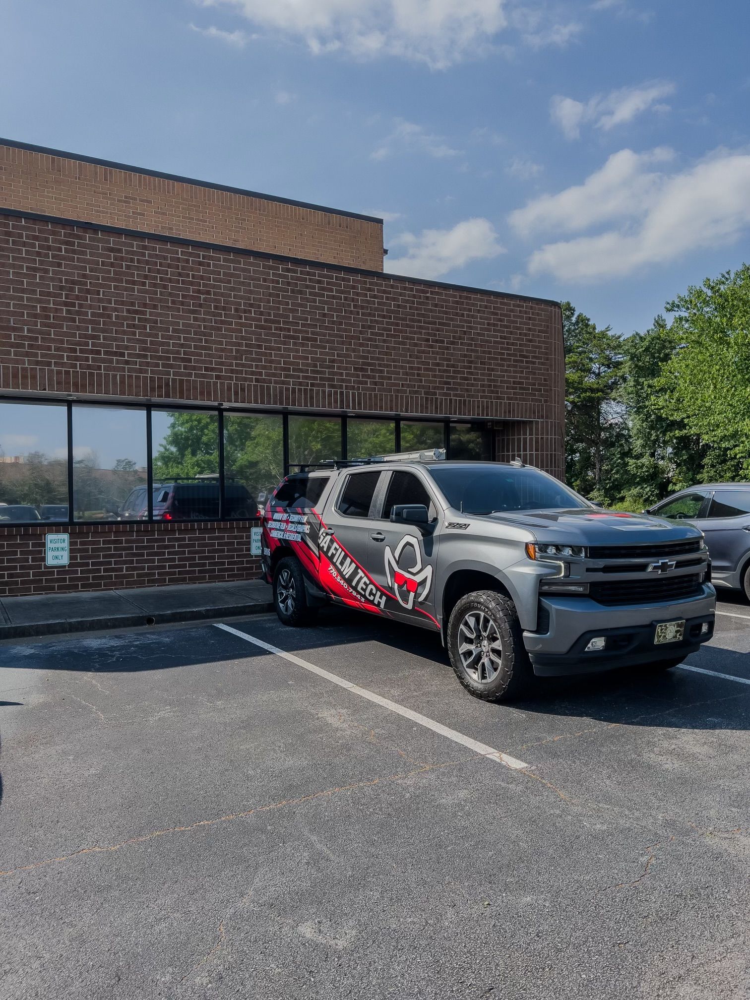 A truck is parked in front of a brick building.