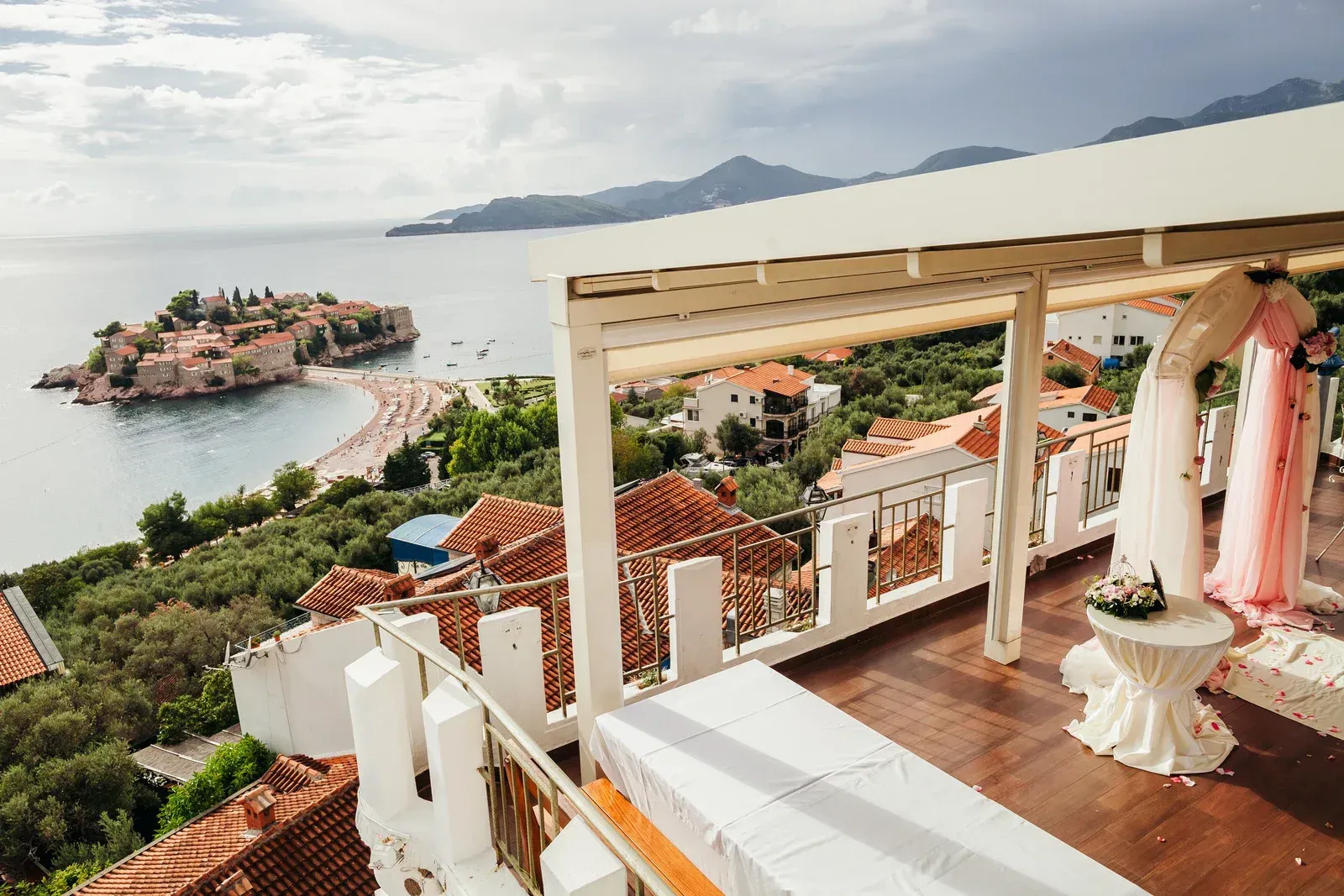 A balcony with a view of the ocean and a small island.