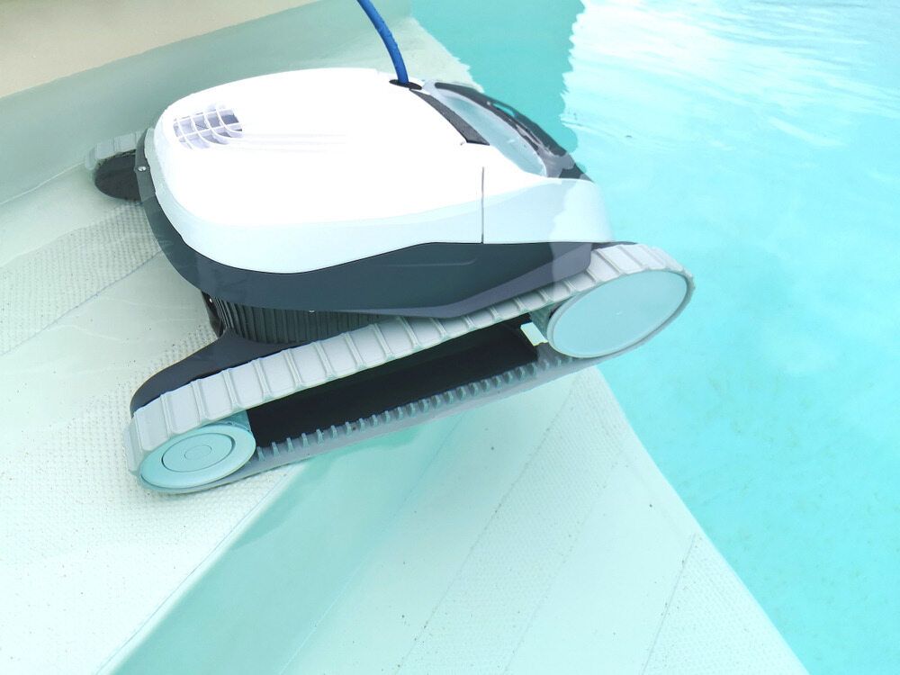 White and Gray Robotic Pool Cleaner on the Edge of a Light Blue Pool, Cleaning — Dean Thomas Pools in Manunda, QLD
