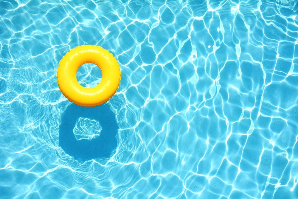 Yellow Inflatable Ring Floating in a Blue, Sun-dappled Pool — Dean Thomas Pools in Port Douglas, QLD