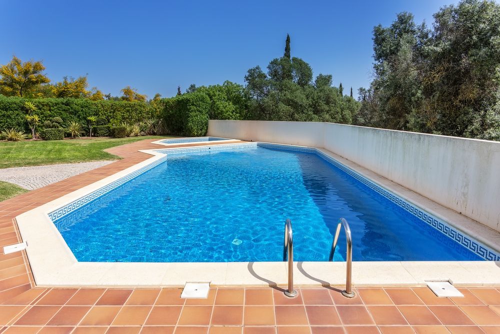 Swimming Pool With Blue Water and Brick Patio — Dean Thomas Pools in Port Douglas, QLD