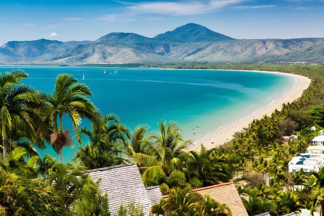 Beach With Turquoise Water and Mountains, Palm Trees in the Foreground — Dean Thomas Pools in Port Douglas, QLD