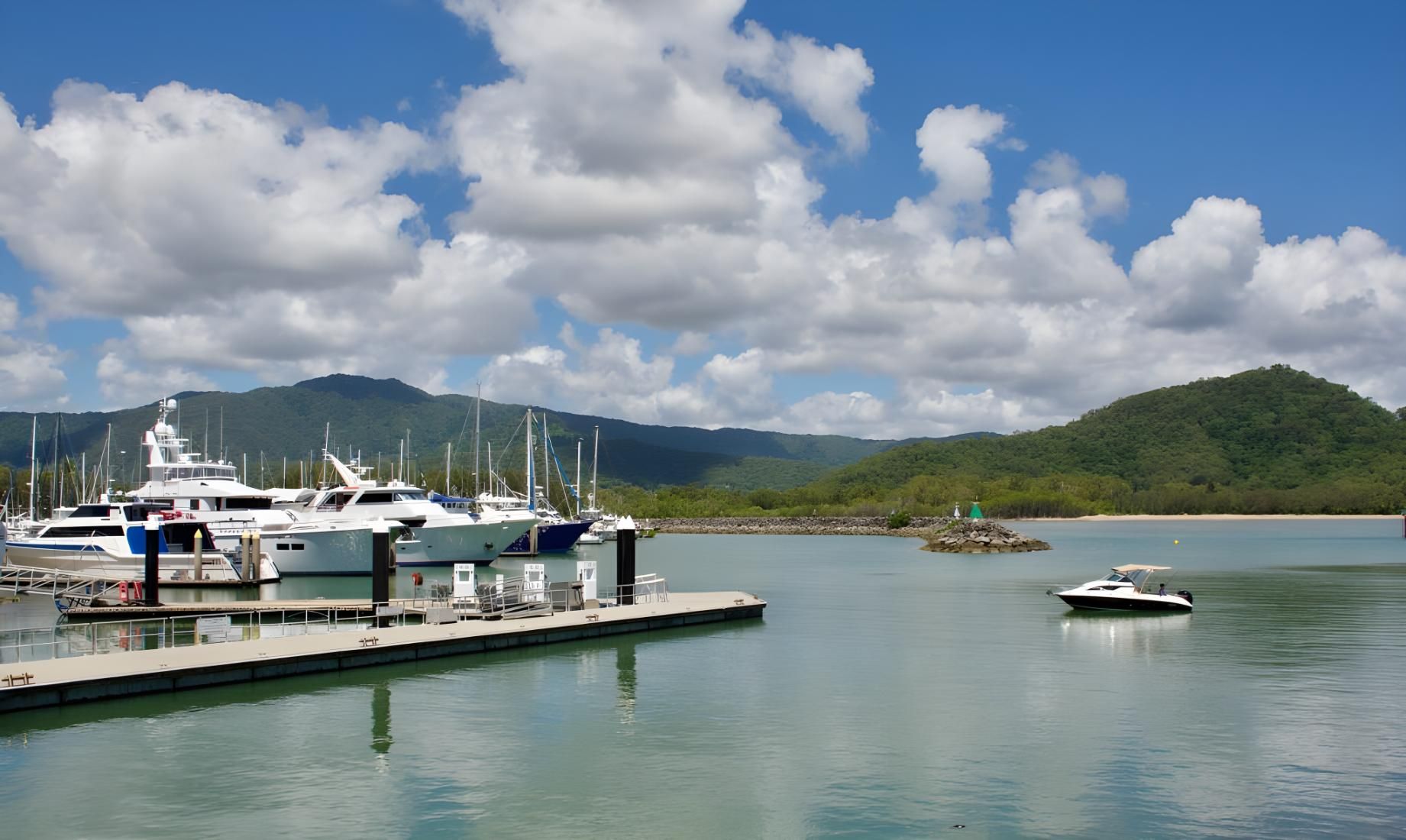 Boats Docked at a Marina With Mountains and Blue Sky in the Background — Dean Thomas Pools in Palm Cove, QLD