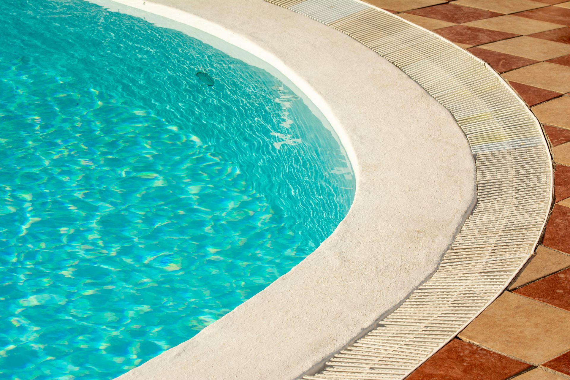 Pool With Blue Water, Surrounded by Gray Stone Patio and Lounge Chairs — Dean Thomas Pools in Manunda, QLD