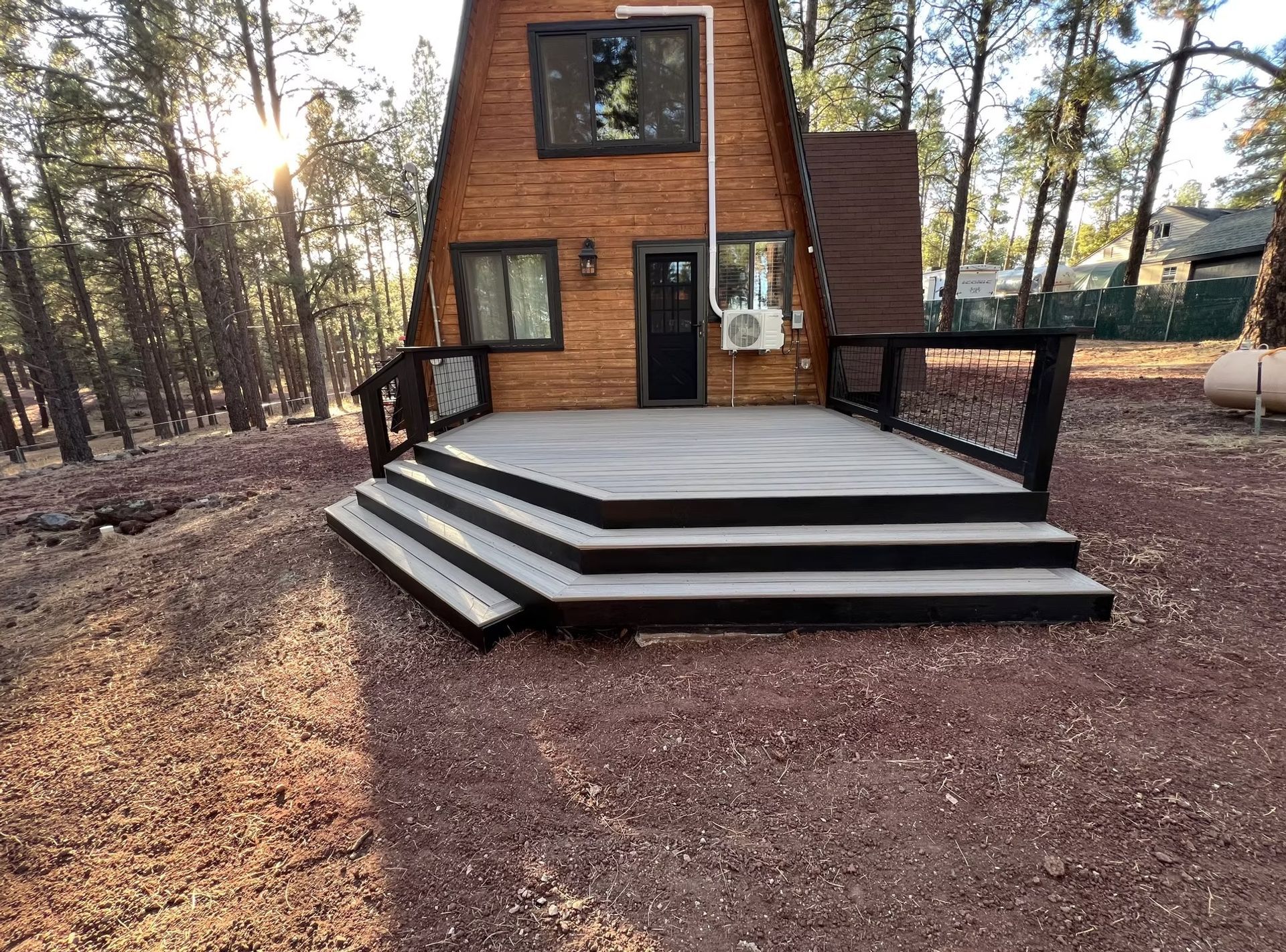 A small wooden house with a large deck in front of it.
