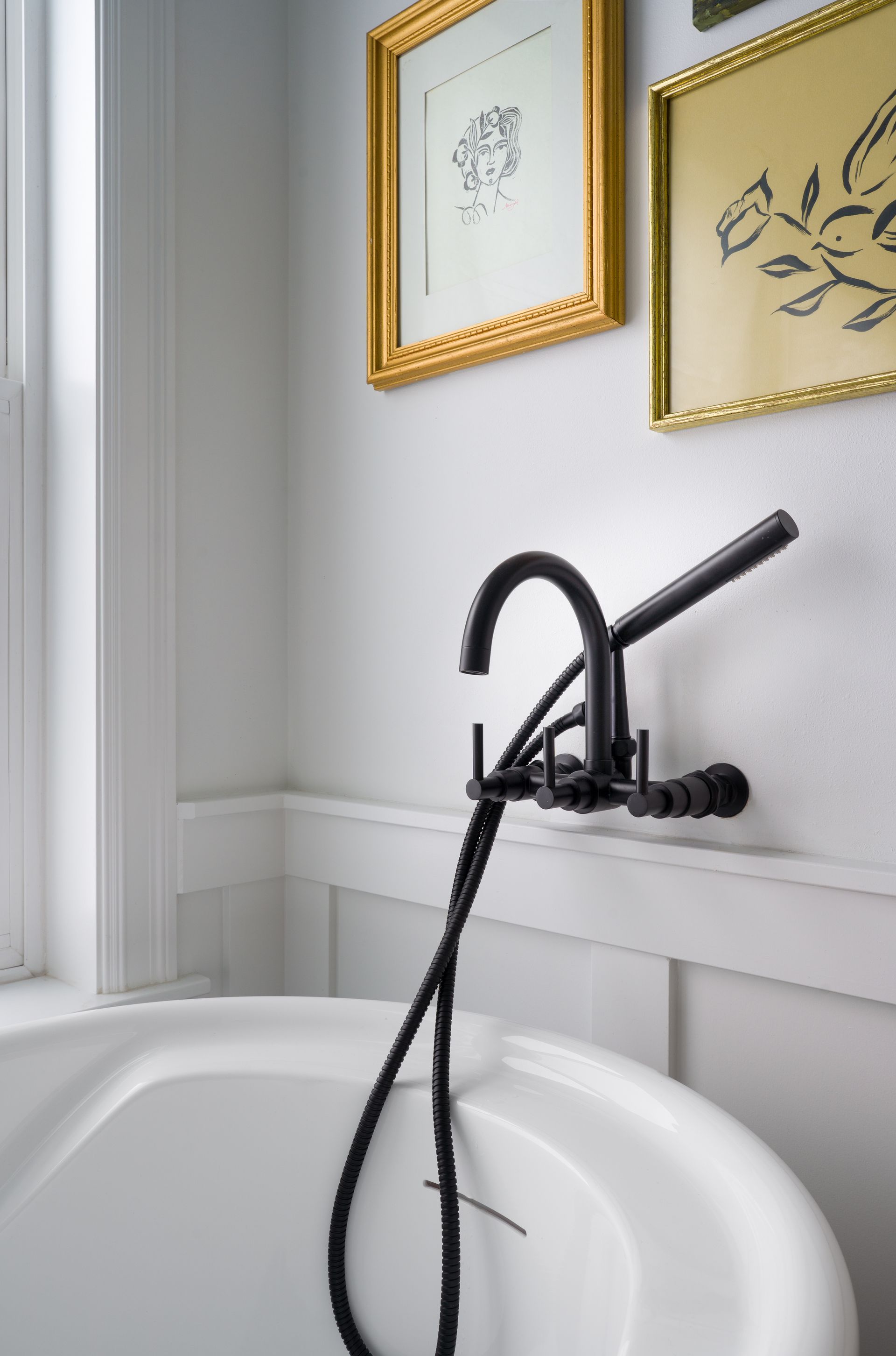 A bathtub with a black faucet in a bathroom in Seattle, WA.  Emily Barrows Photography.  Design by Allison Myers Design. 