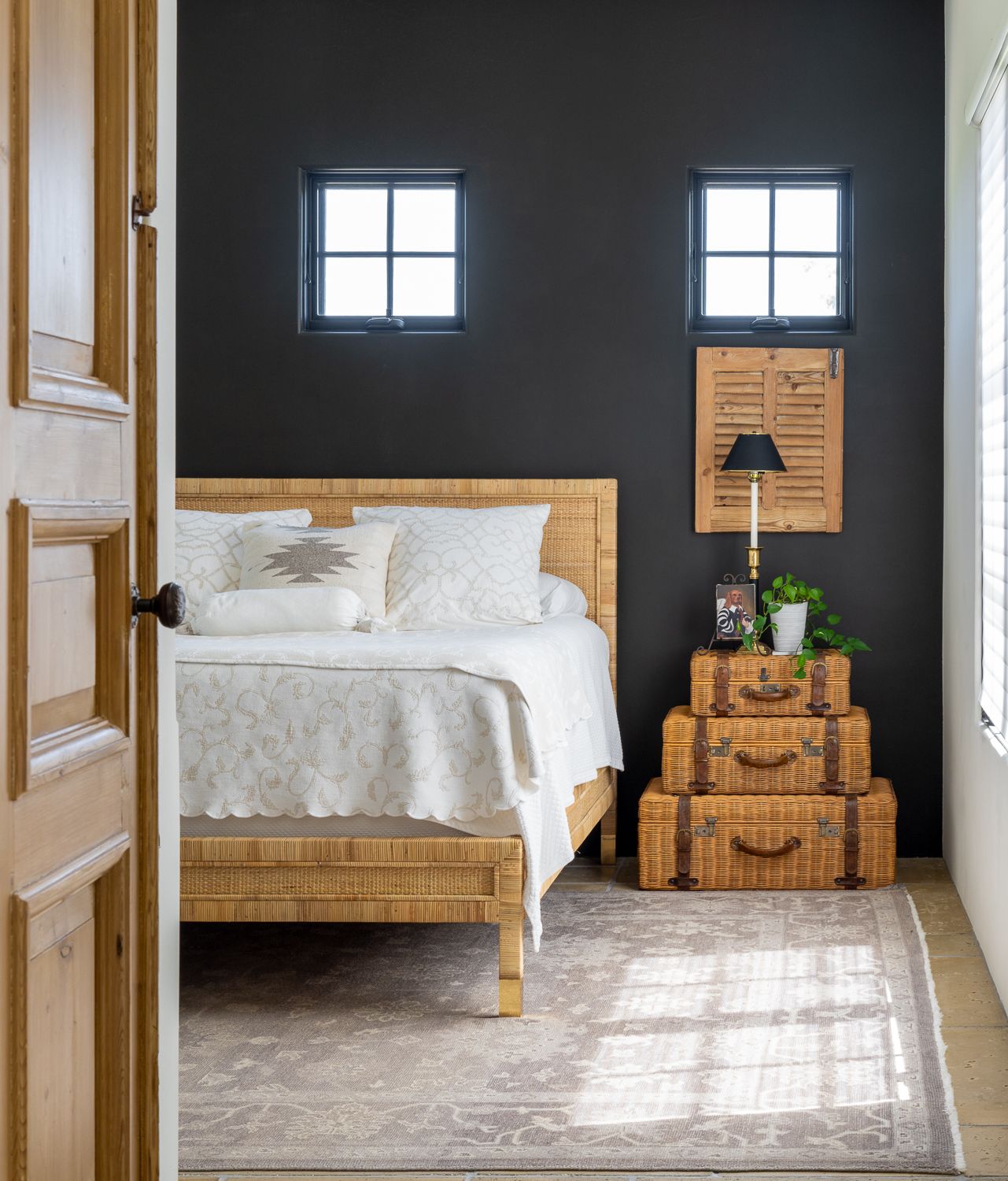 A bedroom with a bed , trunks , and a lamp in Blanco, Photography by Emily Barrows Photography. 