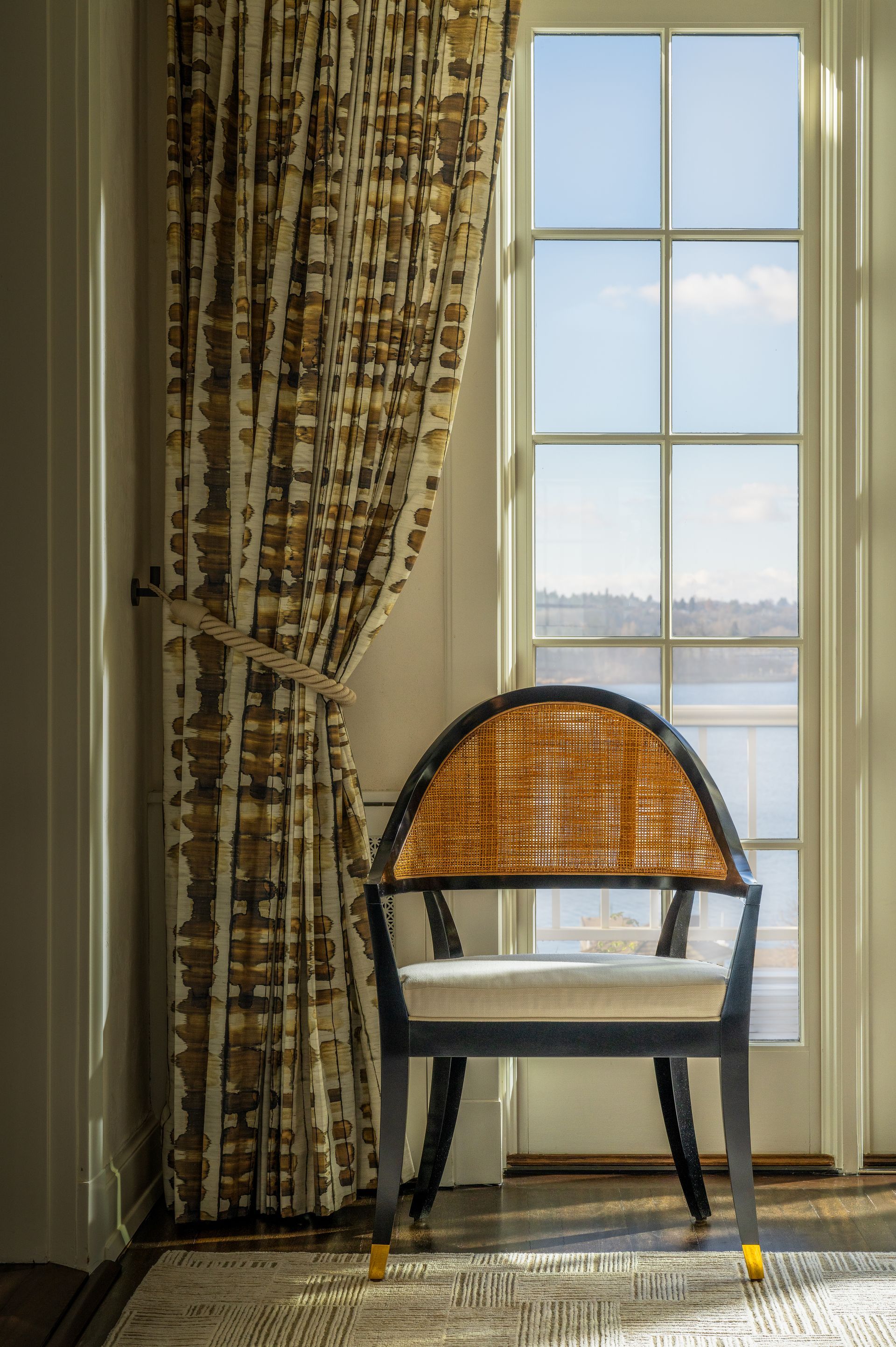 A chair is sitting in front of a window with curtains. Seattle, WA. 