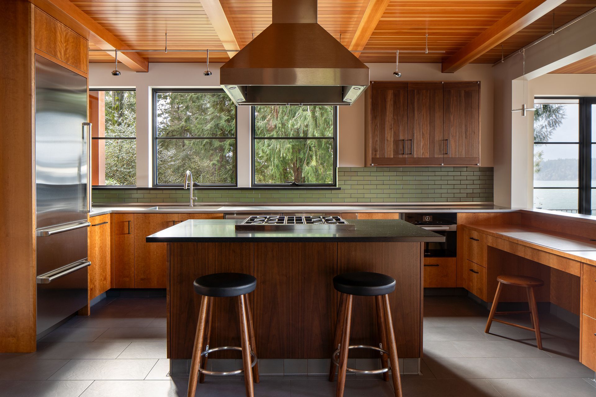Kitchen with wooden cabinets , stainless steel appliances , and large island. Wenzlau Architects. Emily Barrows Photography.