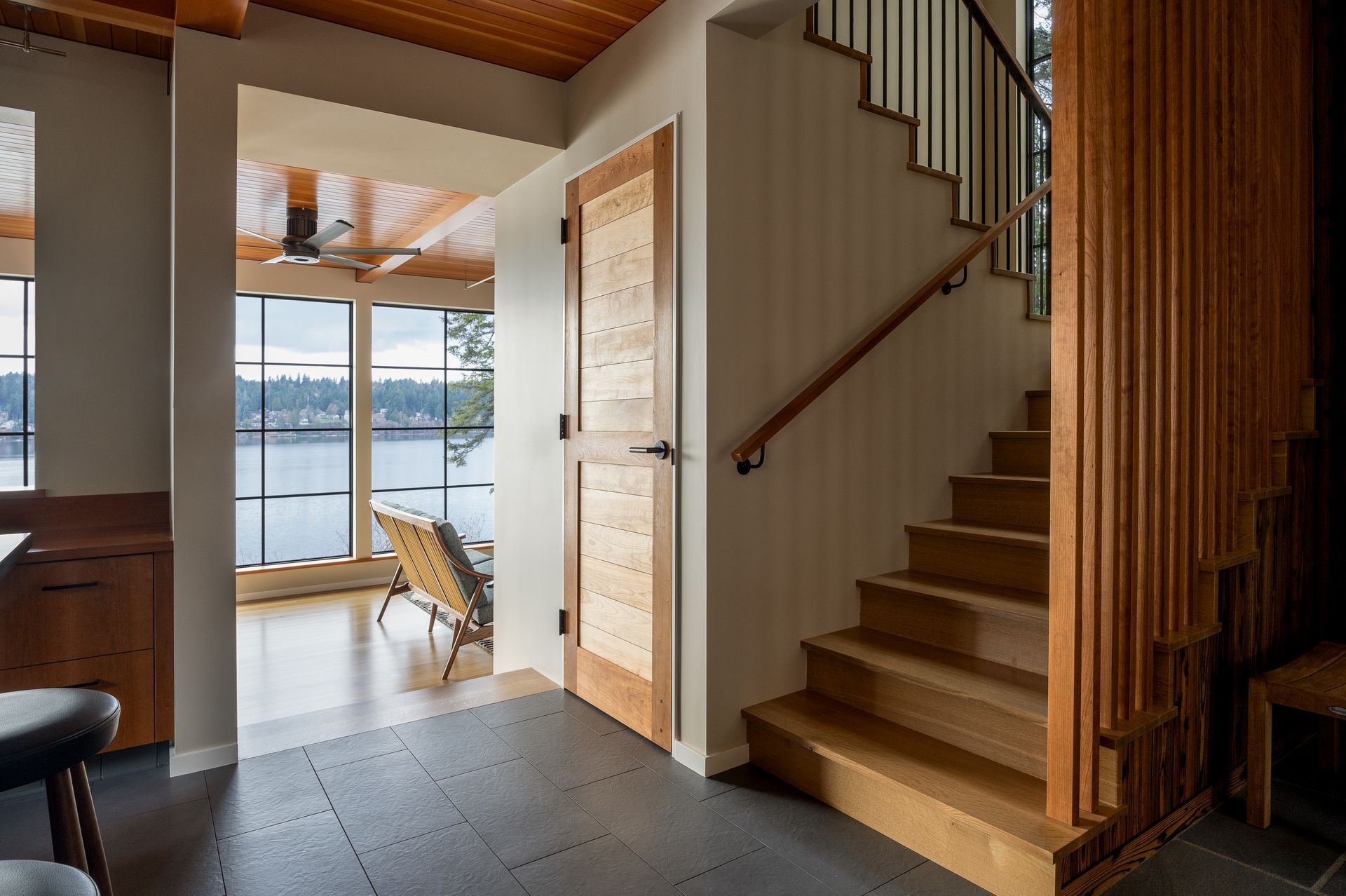 A wooden staircase leading to the second floor of a house. Bainbridge Island. Emily Barrows Photography. Wenzlau Architects.