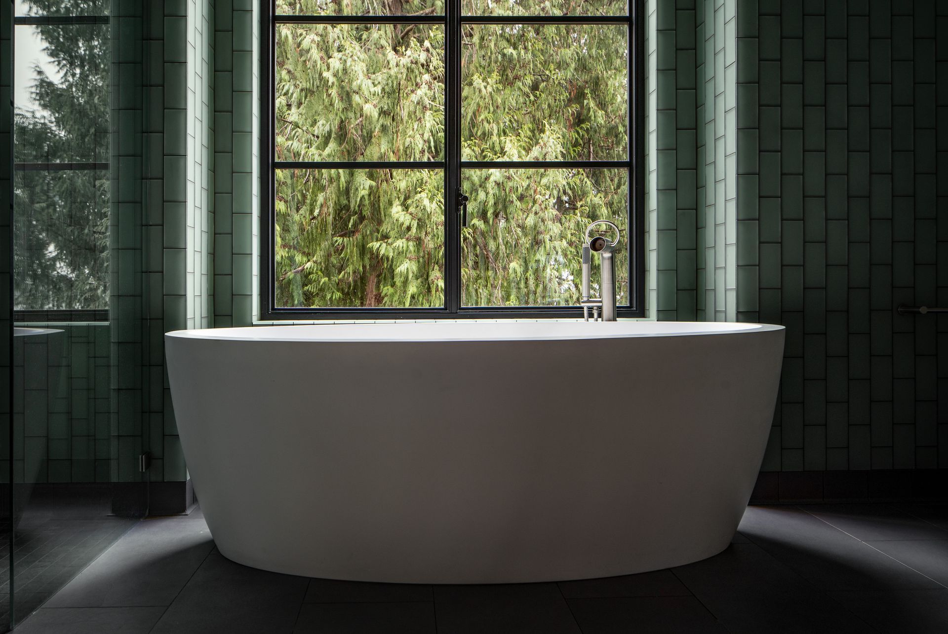 A bathtub in front of a window in a bathroom. Wenzlau Architects. Photography by Emily Barrows Photography. 