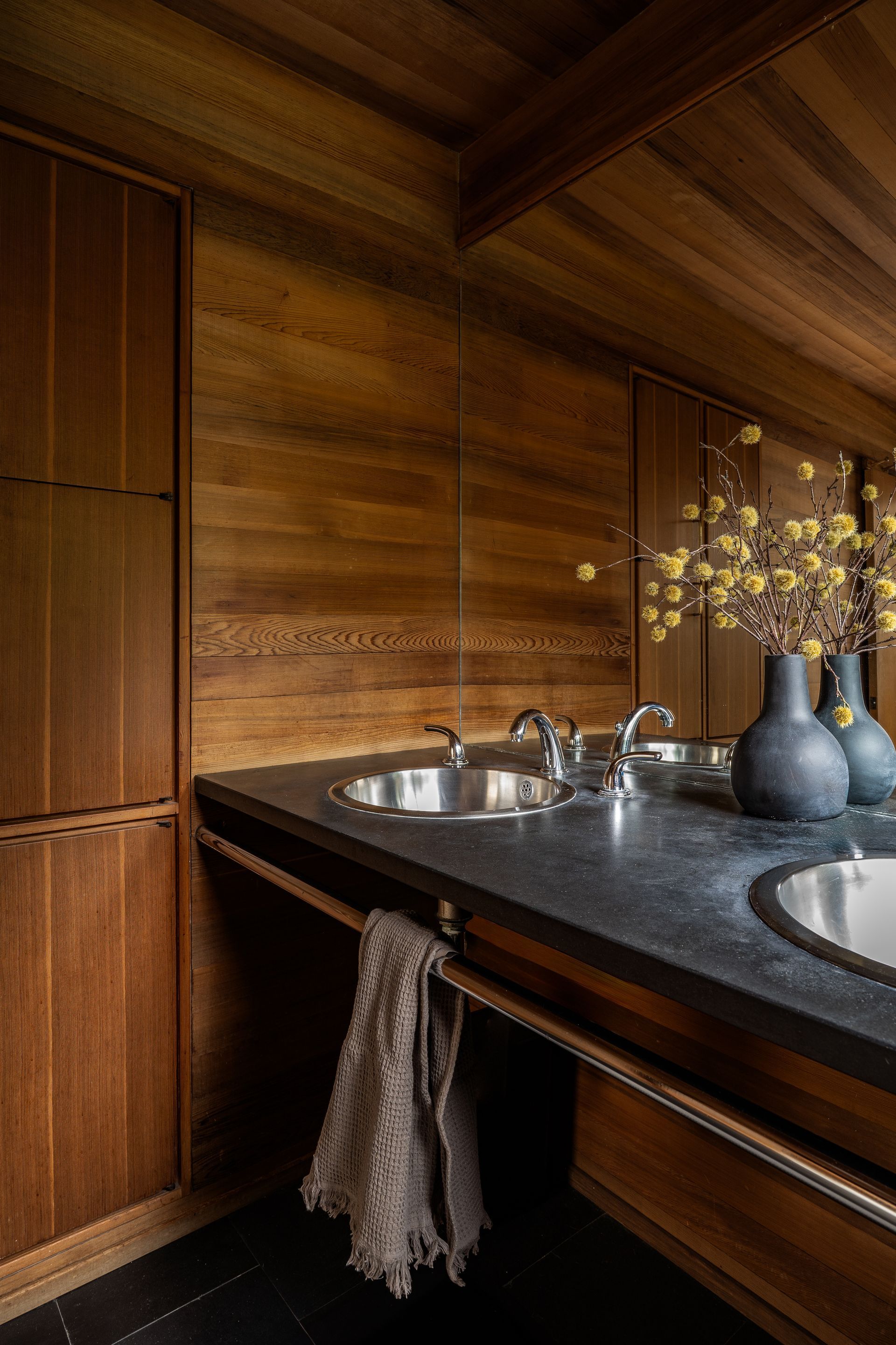 A bathroom with wood walls, two sinks and a mirror. Photography by Emily Barrows Photography. Bainbridge Island, WA.