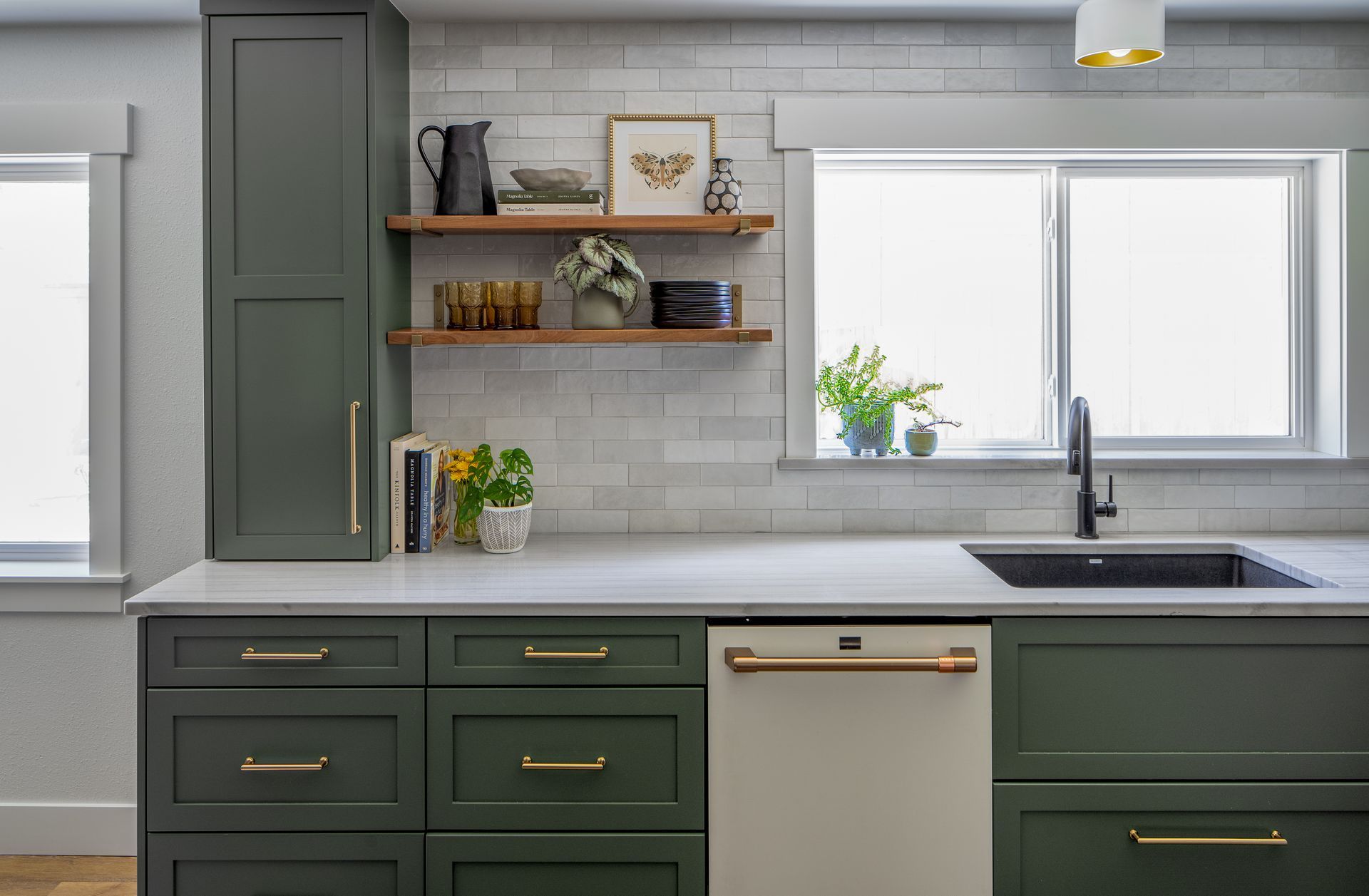 A kitchen with green cabinets , a sink , and a window in Seattle, WA. Allison Myers Design, Emily Barrows Photography. 