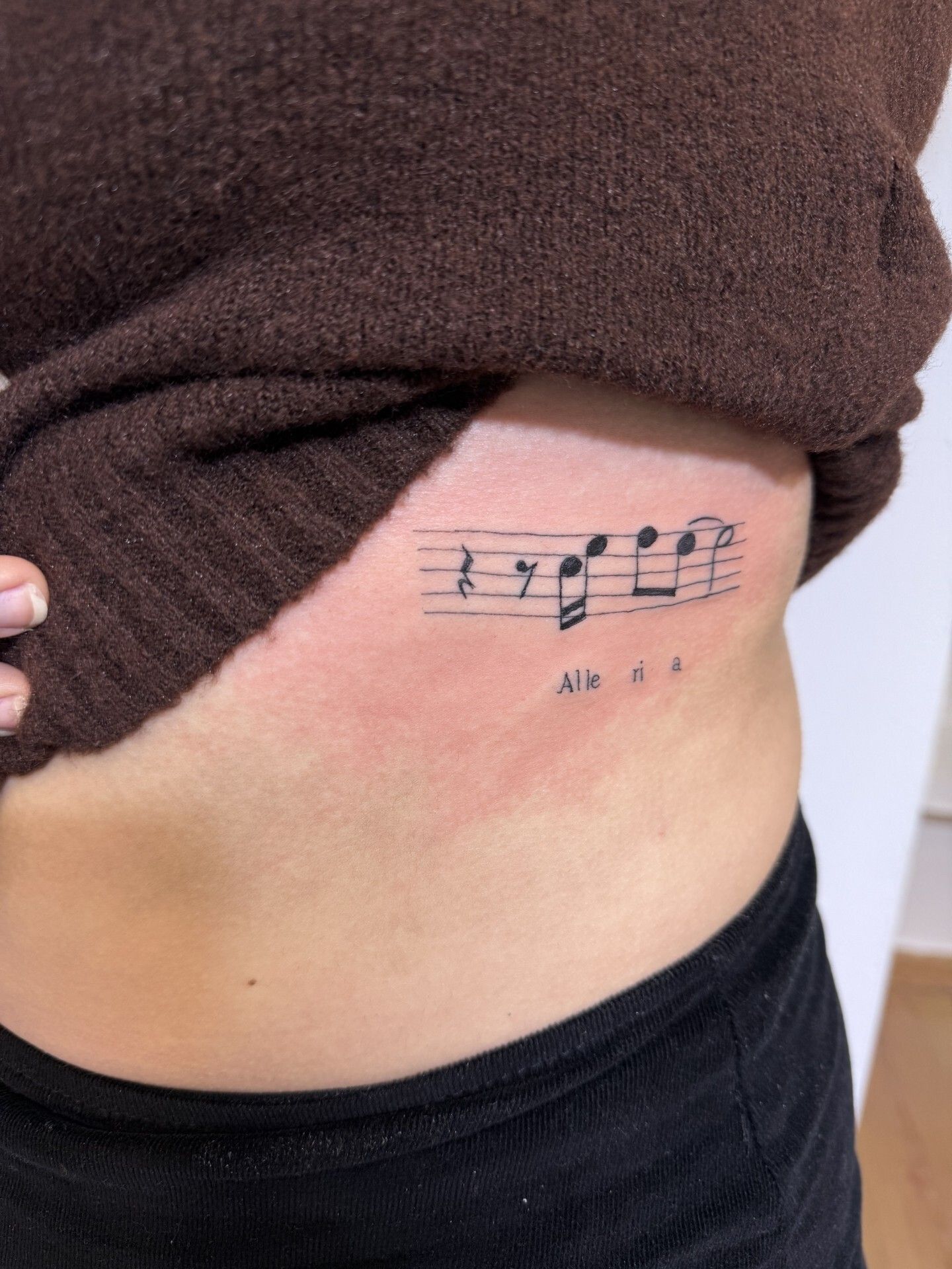 Gamba con tatuaggi floreali e a forma di cuore con motivo paisley.