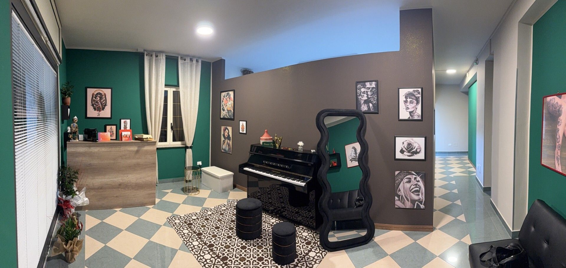 Una stanza con un pianoforte, ritratti e un pavimento a scacchi. Pareti verdi e grigie.