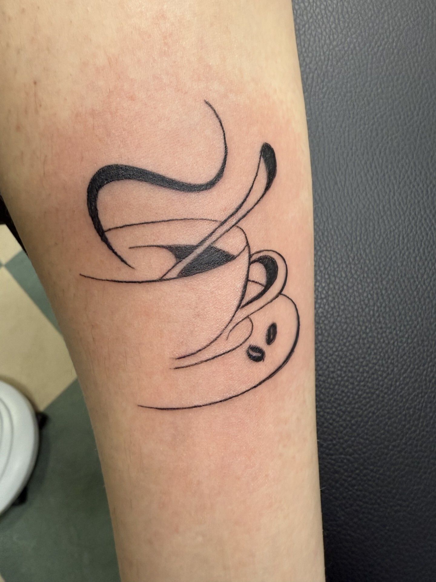 Tatuaggio di donna sorridente sul gomito, nero e grigio.