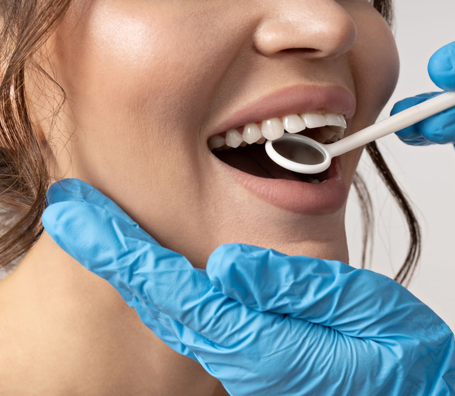 woman getting a dental exam | teeth cleaning and veneers in Waterford MI