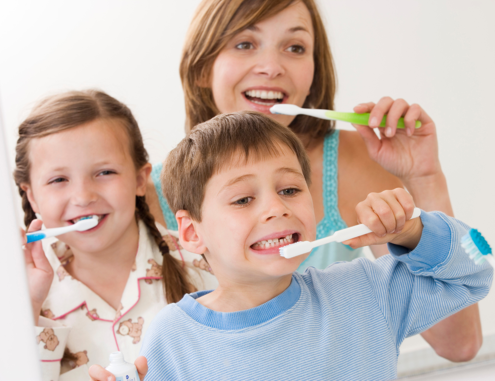 mom and children brushing teeth | family and pediatric dentist in Waterford MI