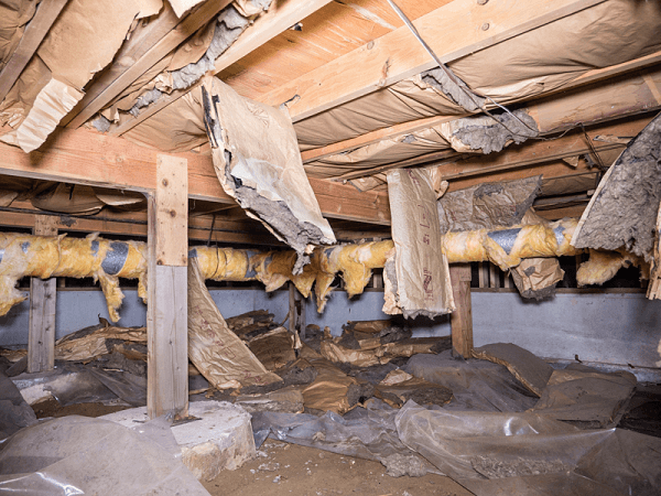 Damaged crawlspace: Insulation, wood, and debris. Brown and yellow materials, potential water damage.