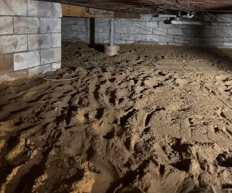 Crawl space with dirt floor, concrete block walls, and wooden beams. A metal support post is visible.