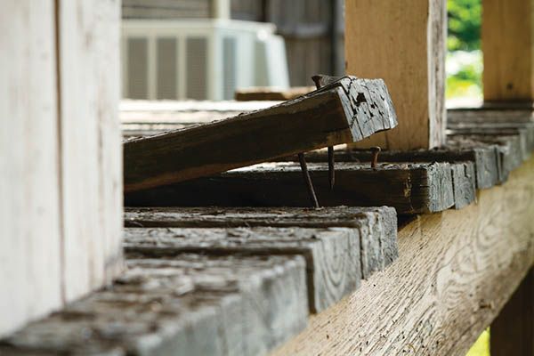 White wall with a prominent diagonal crack; blue door and white trim visible.