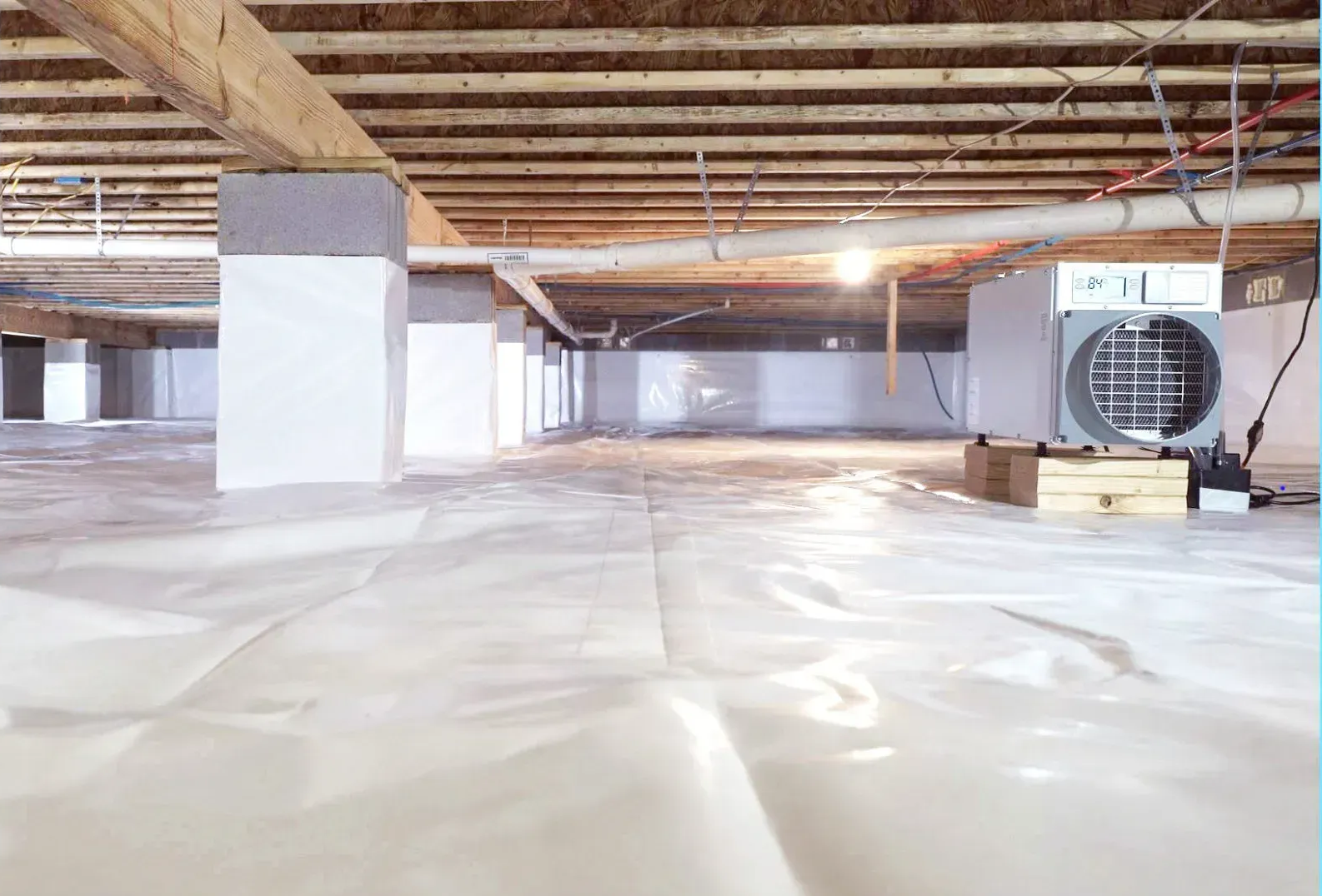 Damaged crawl space: insulation, wood beams, and torn materials.