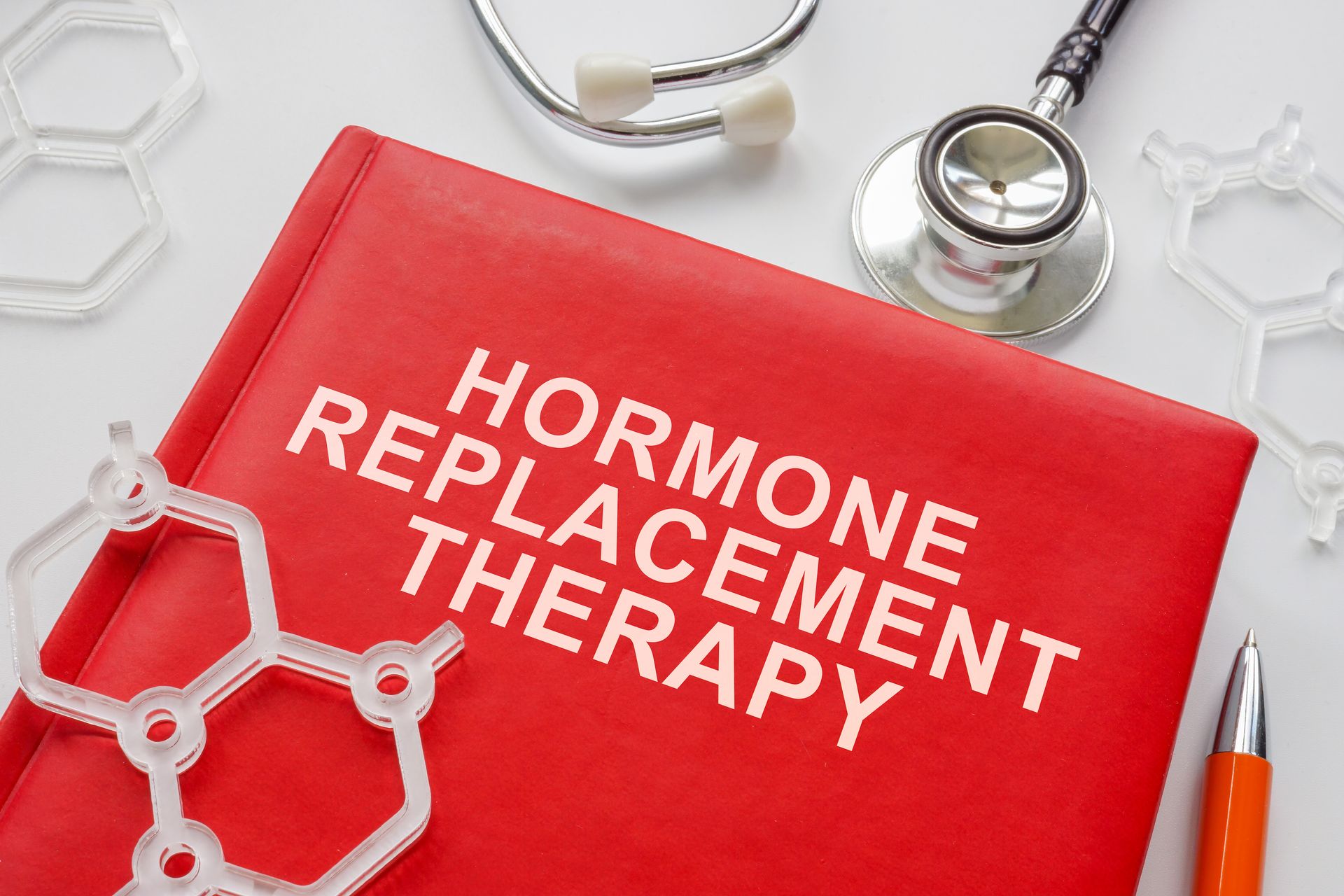A red book with the words `` hormone replacement therapy '' written on it.
