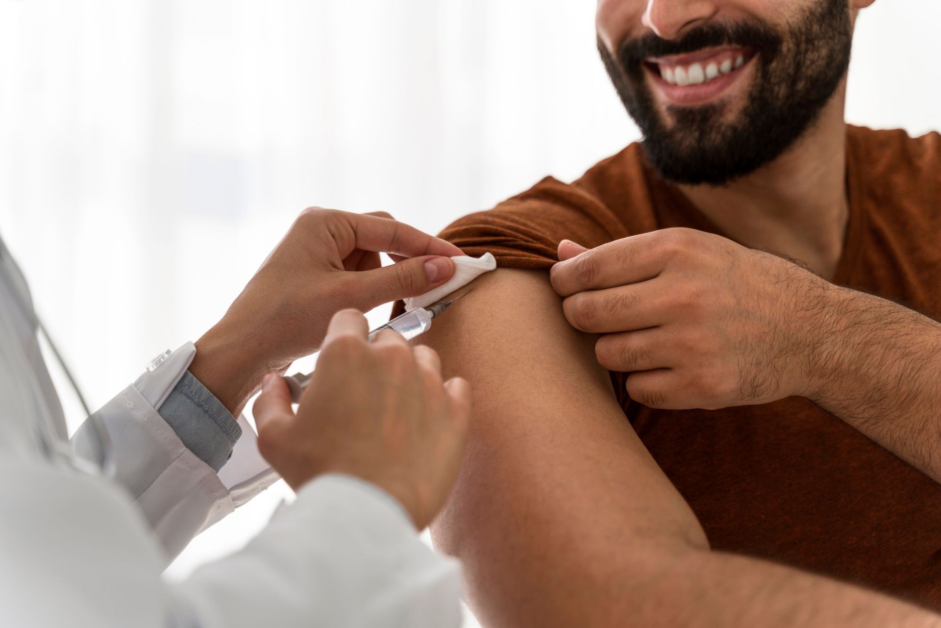 A man is getting an injection in his arm by a doctor.
