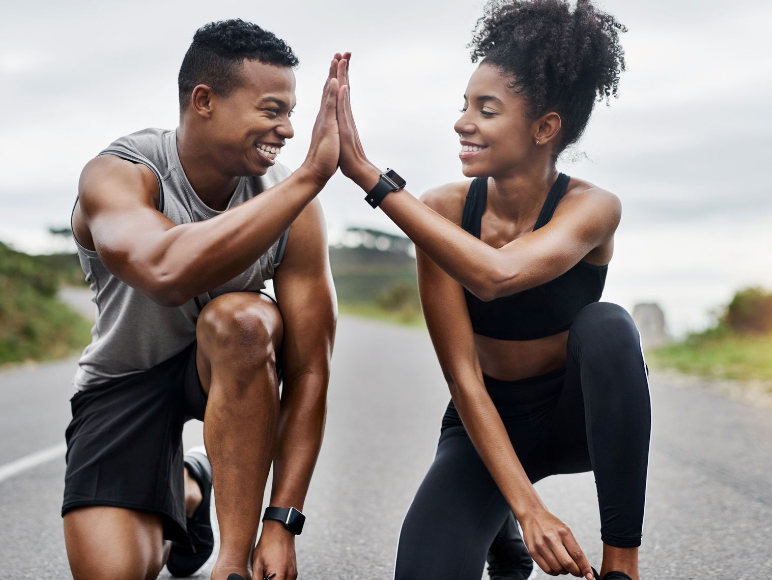 A man and a woman are giving each other a high five.