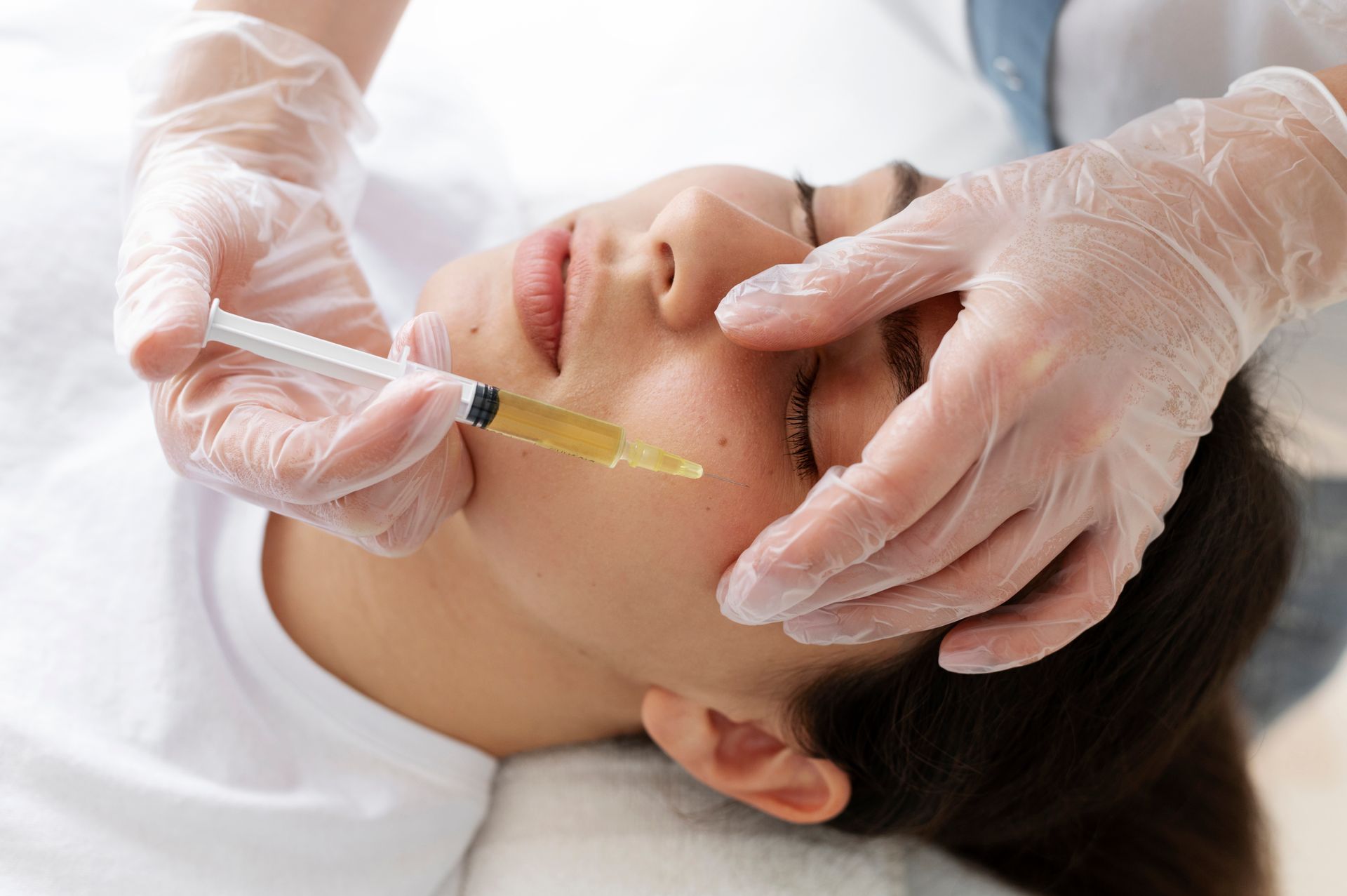 A woman is getting a botox injection in her face.