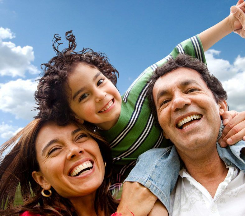 A Man and Woman Joyfully carry a child on their Shoulders — Family Counselling in Kingscliff, NSW