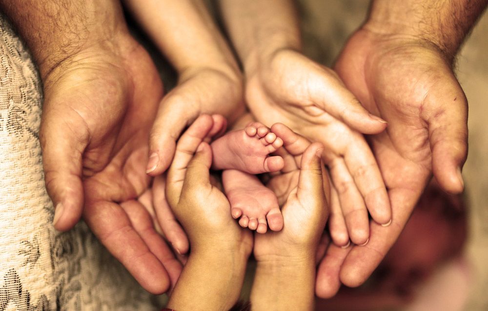 A Family Holds A Baby's Foot In Their Hands — Mediator & Counsellor in Kingscliff, NSW