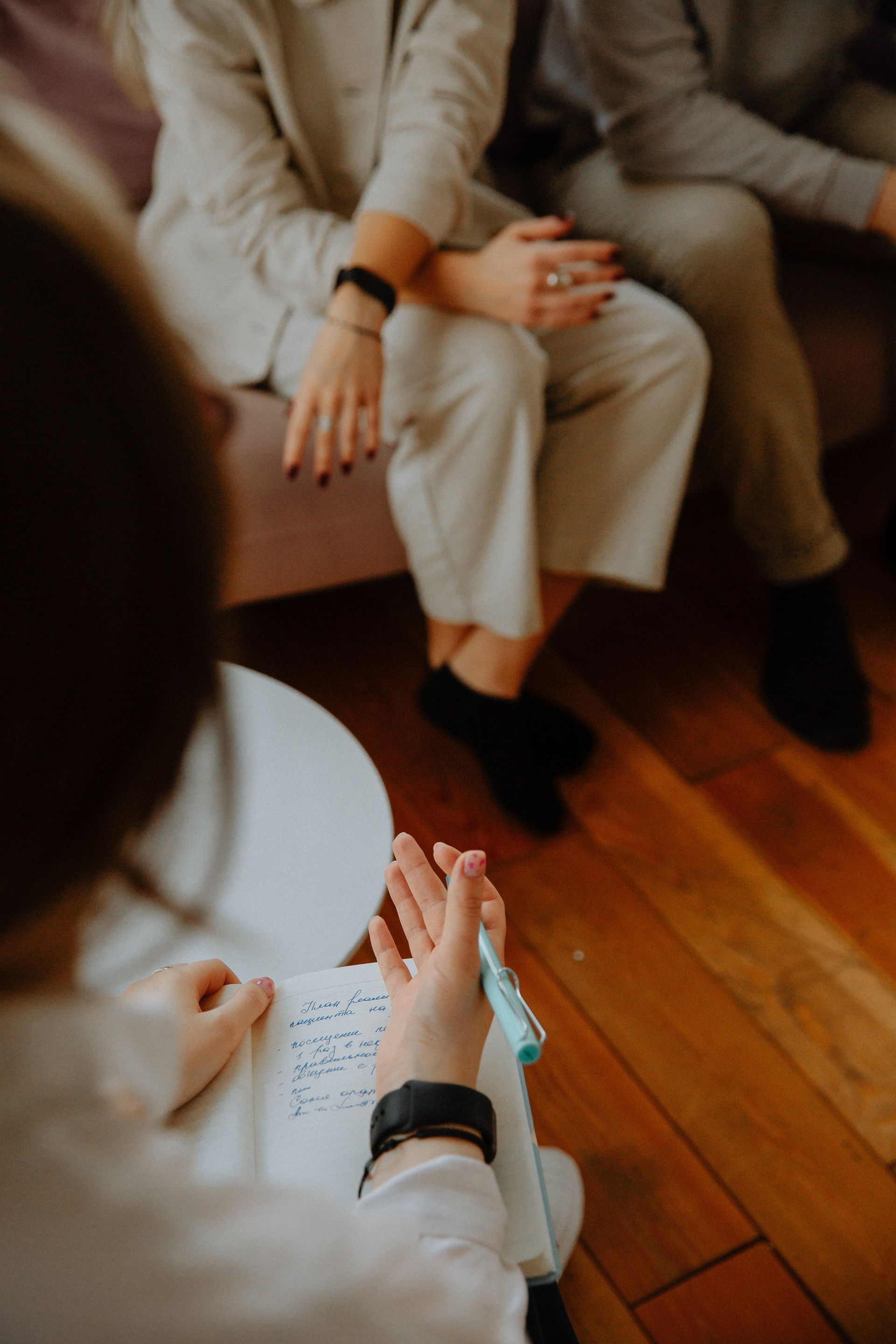A Man And Woman Sit On A Couch With A Woman Writing On A Piece Of Paper — Post-Separation & Divorce Counselling in Kingscliff, NSW