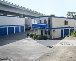 A white building with blue garage doors and a blue awning.