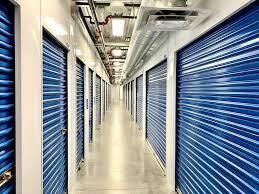 A long hallway filled with blue doors in a storage facility.