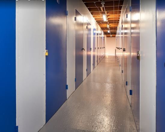A long hallway with blue and white doors in a building