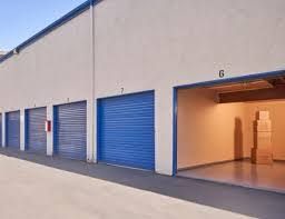 A row of storage units with blue doors on a building.