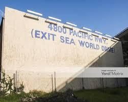 A large billboard on the side of a building that says `` exit sea world drive ''.