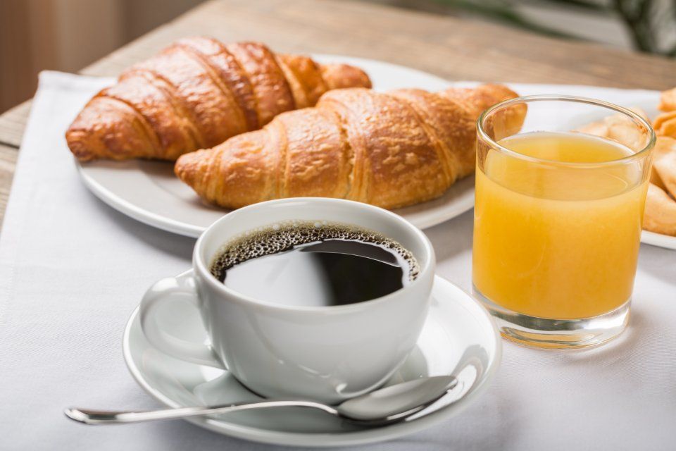 Colazione con caffè, croissant e spremuta