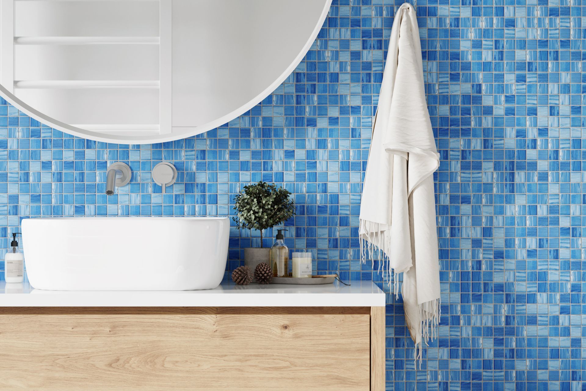 a bathroom with blue tiles , a sink , a mirror and a towel hanging on the wall .