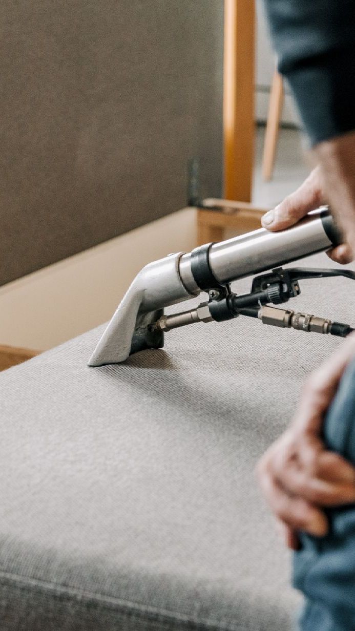 a cleaner using professional grade vacuum to clean off upholstery