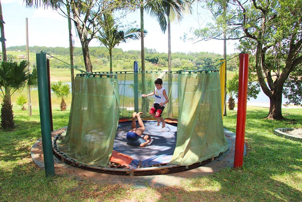 Um grupo de crianças está brincando em um trampolim em um parque.