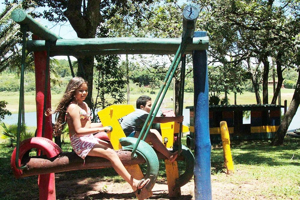 Uma menina está sentada em um balanço de pneu em um parque