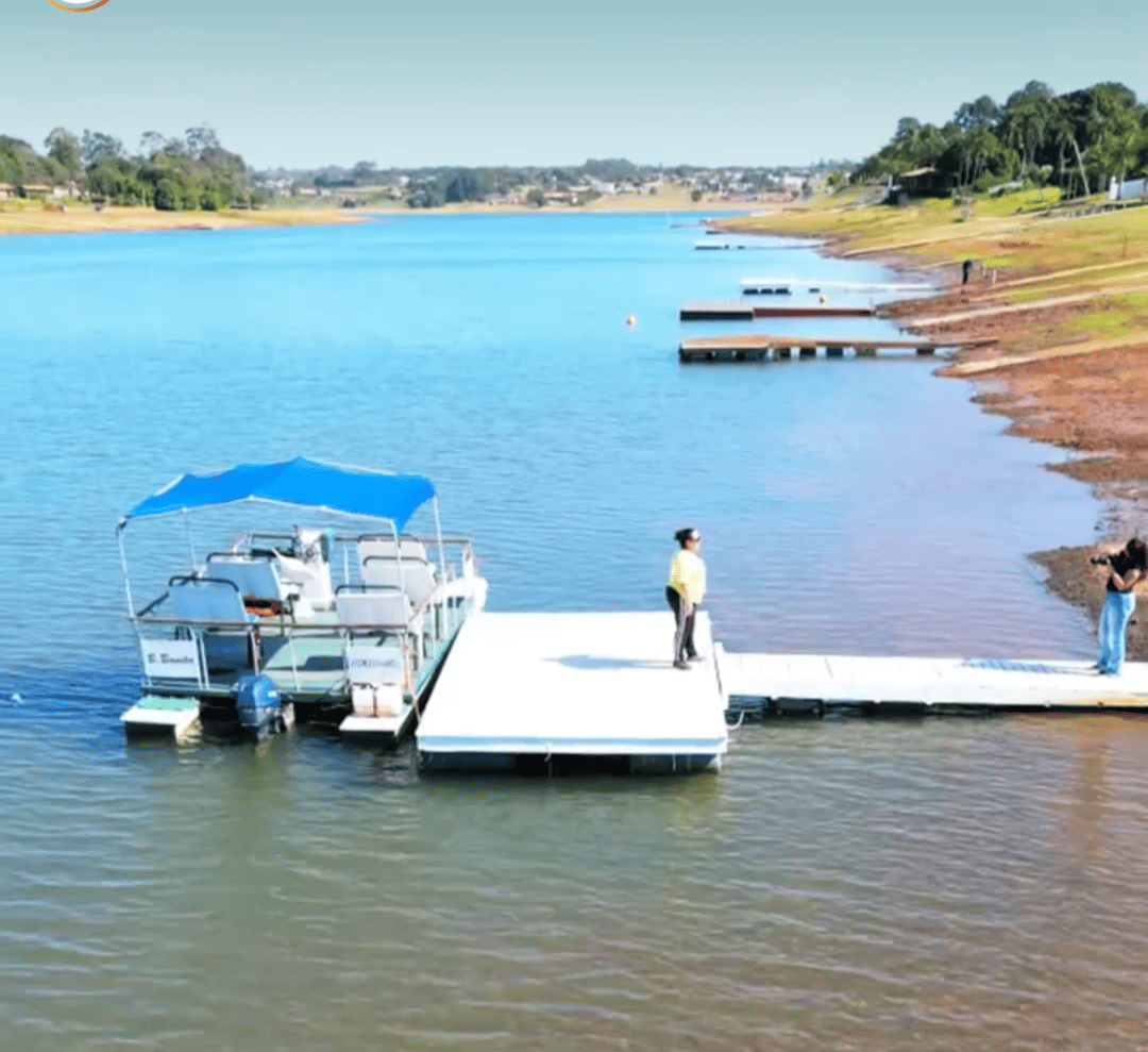 Um barco com uma cobertura azul está atracado em um cais