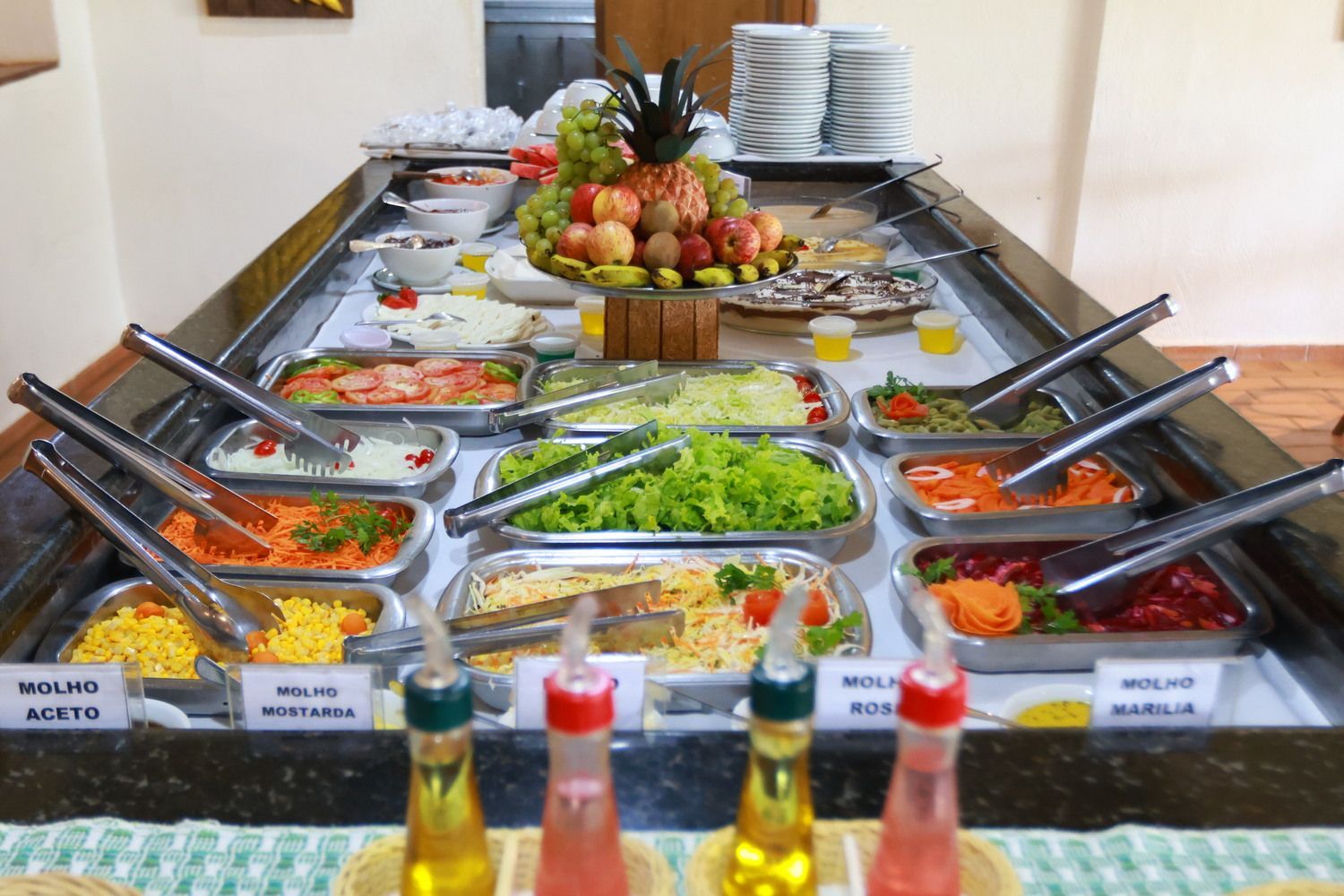 Uma mesa de saladas com muitos vegetais e frutas