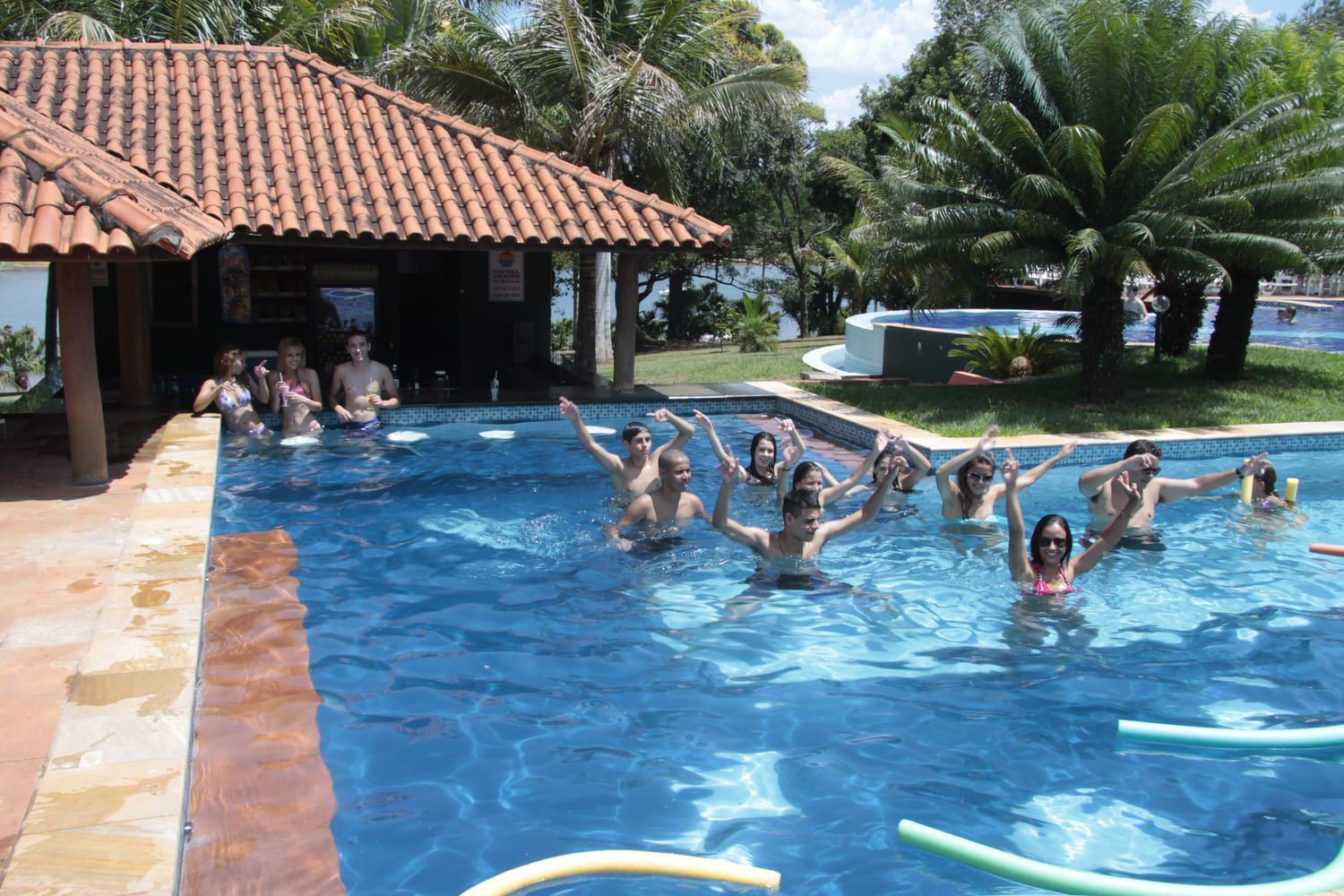 Um grupo de pessoas está fazendo exercícios em uma piscina