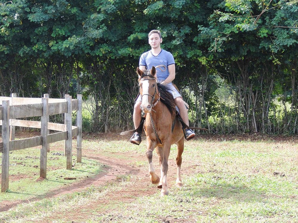 Um homem está cavalgando em um campo.