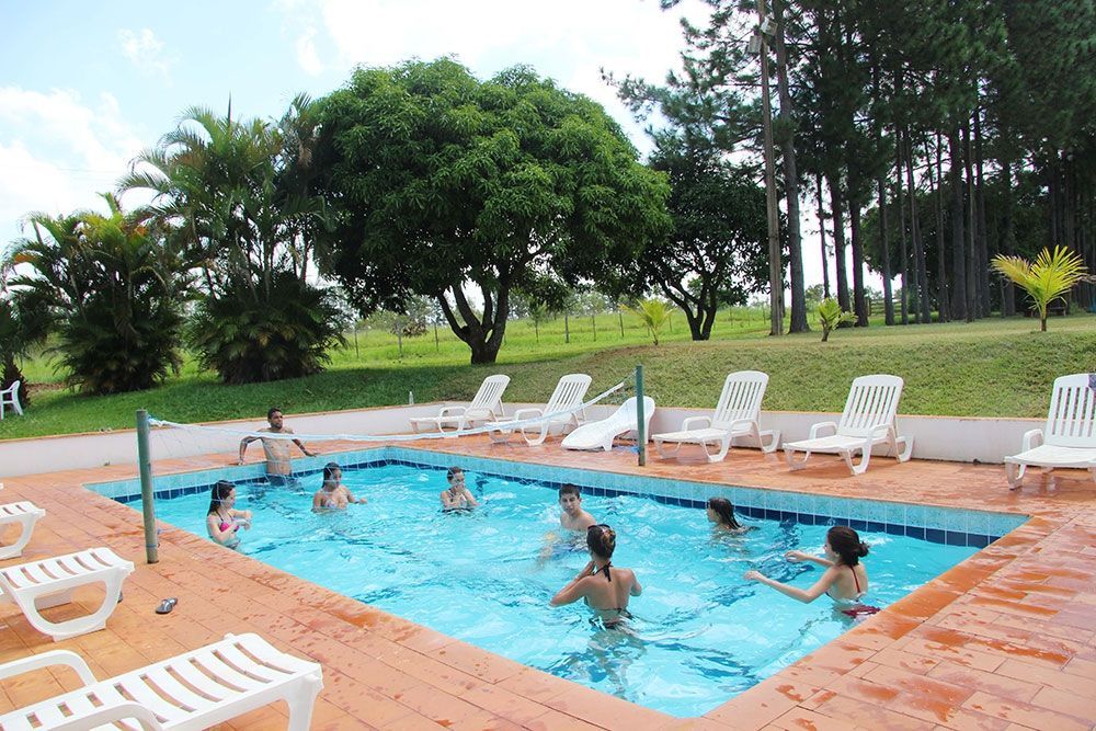 Um grupo de pessoas está nadando em uma grande piscina