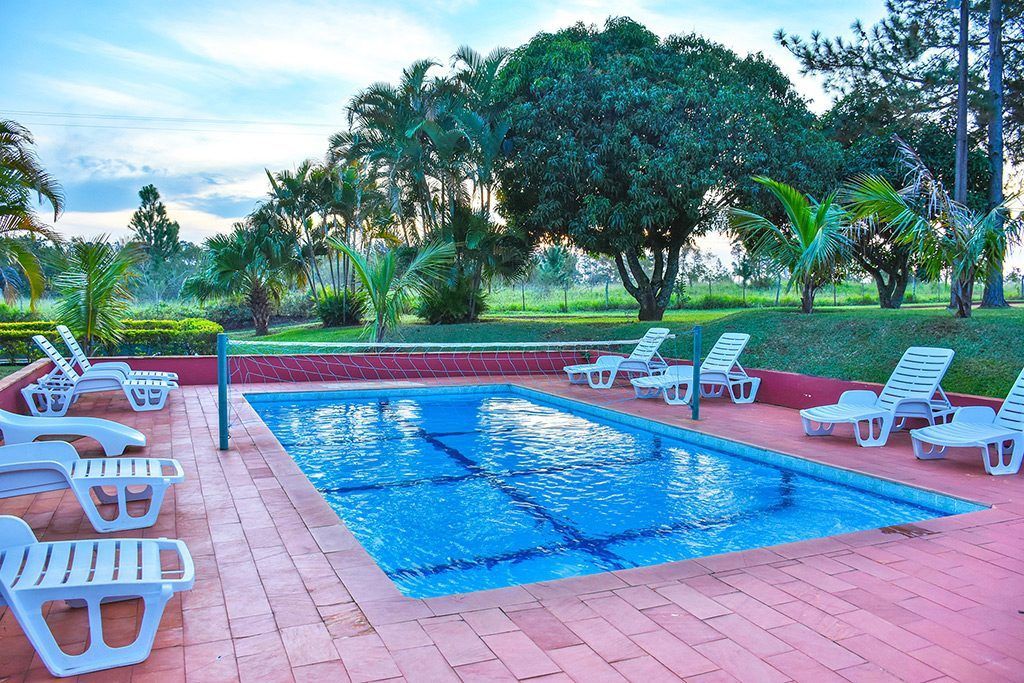 Uma grande piscina rodeada de cadeiras e árvores