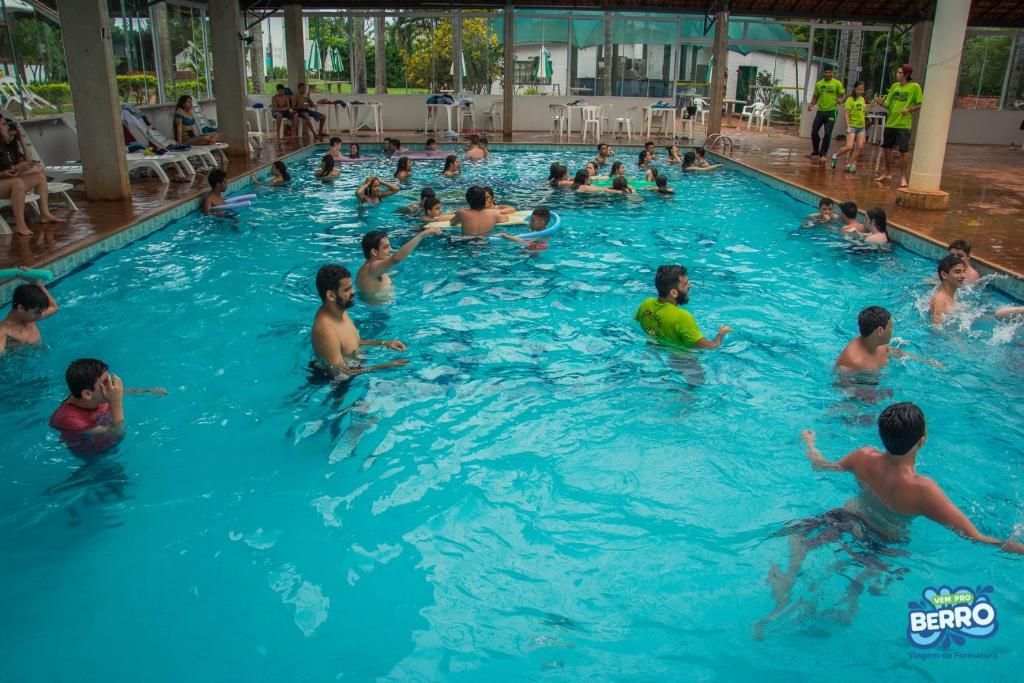 Um grupo de pessoas está nadando em uma grande piscina